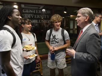 President Doug Hicks conversing with students